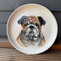 Hand-painted decorative plate featuring a detailed portrayal of a bulldog face.
