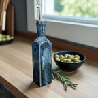 Handmade Ceramic Olive Oil Bottle with deep blue glaze and stainless steel pourer on a kitchen countertop