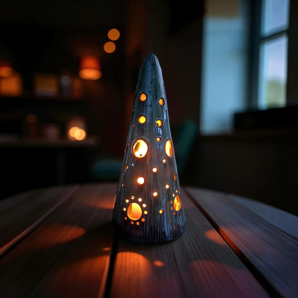 Handmade ceramic tealight tree with glowing light patterns on a wooden table, perfect for cozy evenings.