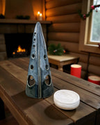 Handmade ceramic tealight tree – glossy winter blue placed on a wooden table in a cozy indoor setting.