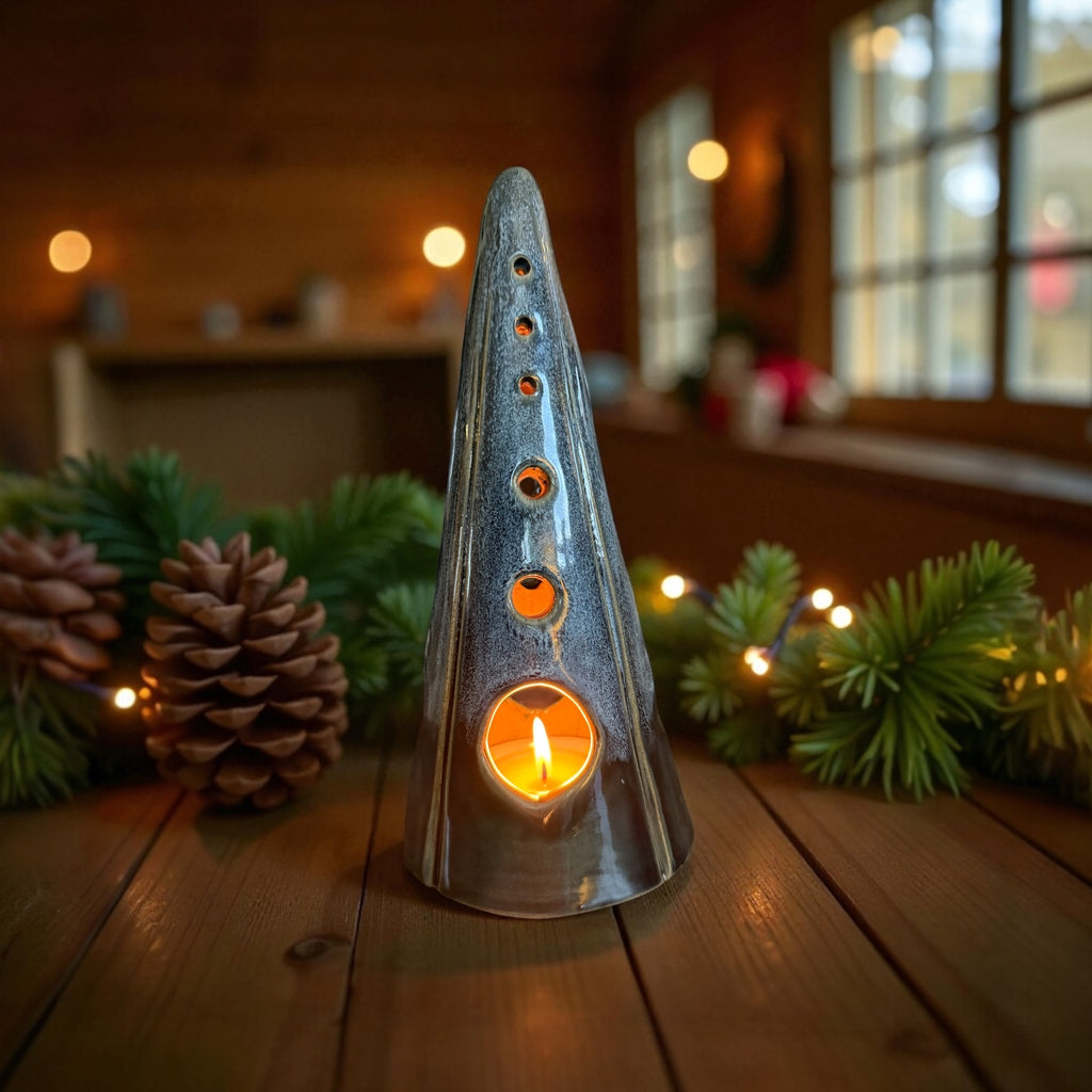 Handmade ceramic tealight tree – glossy winter blue illuminating a cozy space with frosty tones and cut-out patterns.