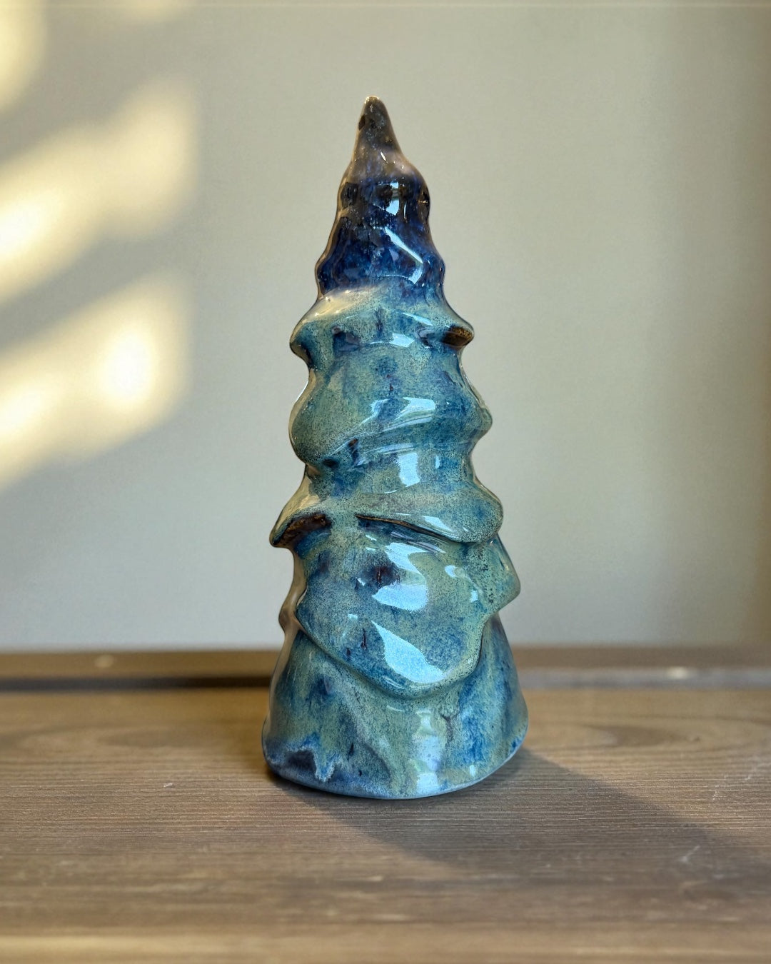 Handmade decorative ceramic tree in glossy blue-green glaze, showcasing a sculptural evergreen silhouette.