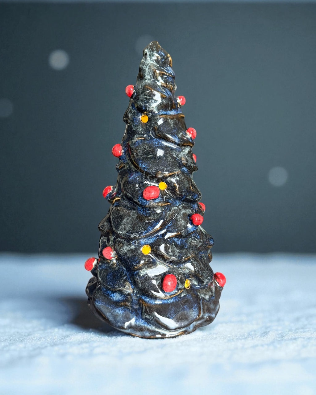 Handmade ceramic Christmas tree with glossy dark glaze and red ornaments, ideal for festive decor.
