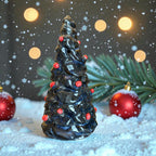 Handmade ceramic Christmas tree decorated with red ornaments, featuring a glossy dark glaze and festive lights.