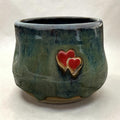 Handmade ceramic cup – green glaze with heart detail