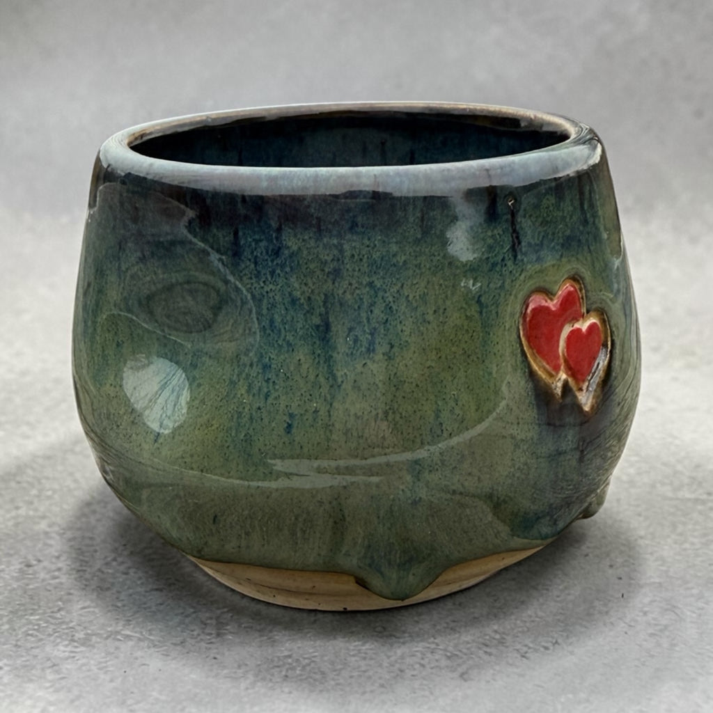 Handmade ceramic cup – green glaze with heart detail